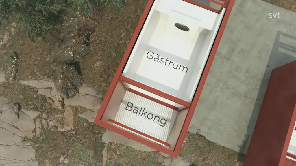 Stiligt - Flygfoto över en liten byggnad märkt "Gästrum" (gästrum) och "Balkong" (balkong) intill stenig mark och en betongyta.