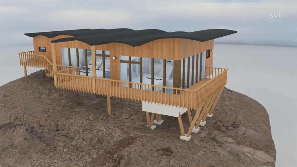 Stiligt - Ett modernt trähus med stora glasfönster och ett vågigt svart tak ligger högt upp på en klippig kulle med ett omslutande däck.