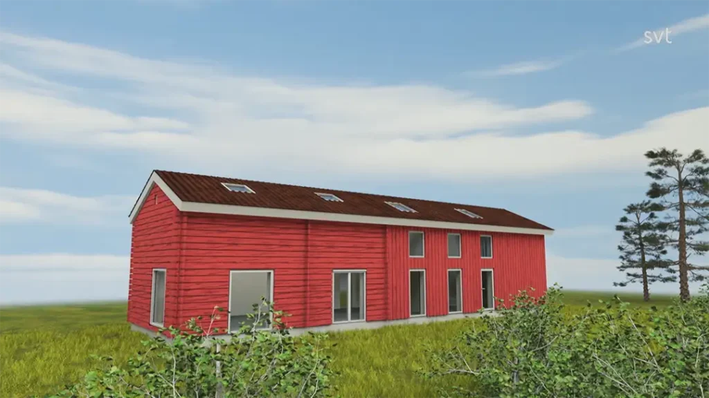 Stiligt - En modern röd tvåvåningsbyggnad med ett sadeltak och flera fönster står på ett gräsbevuxet fält under en delvis molnig himmel.